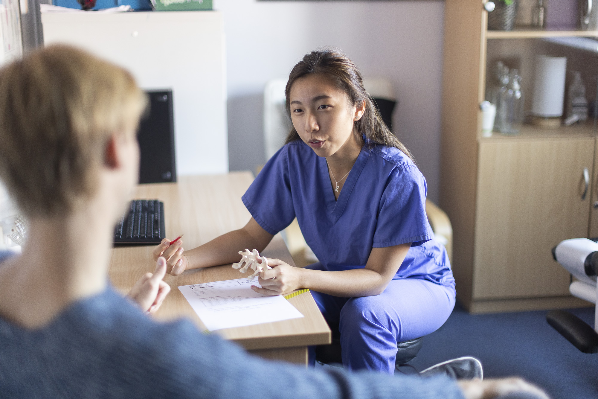 clinician speaking with patient in a consultation room