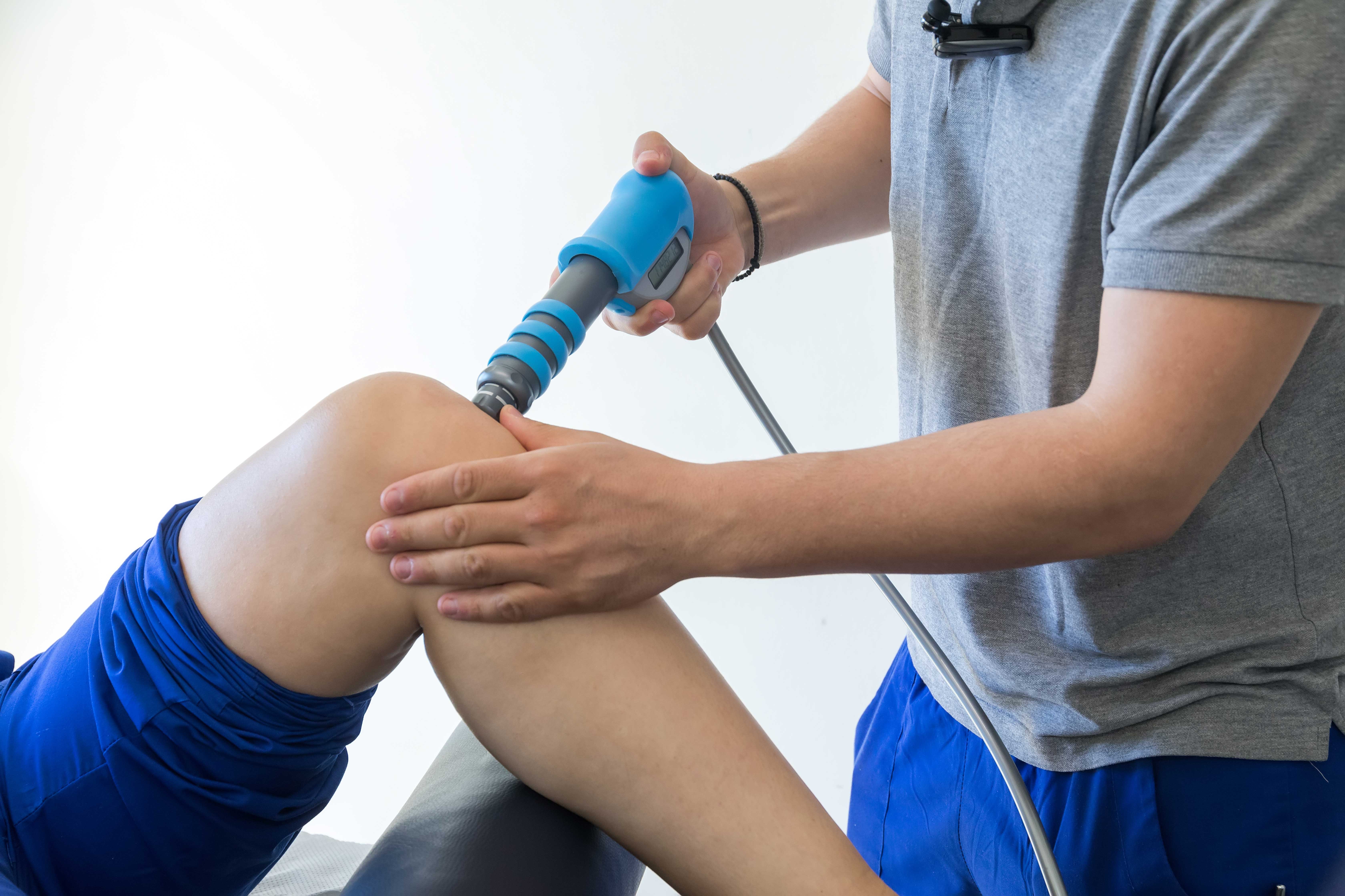shockwave therapy session taking place on a patient's knee