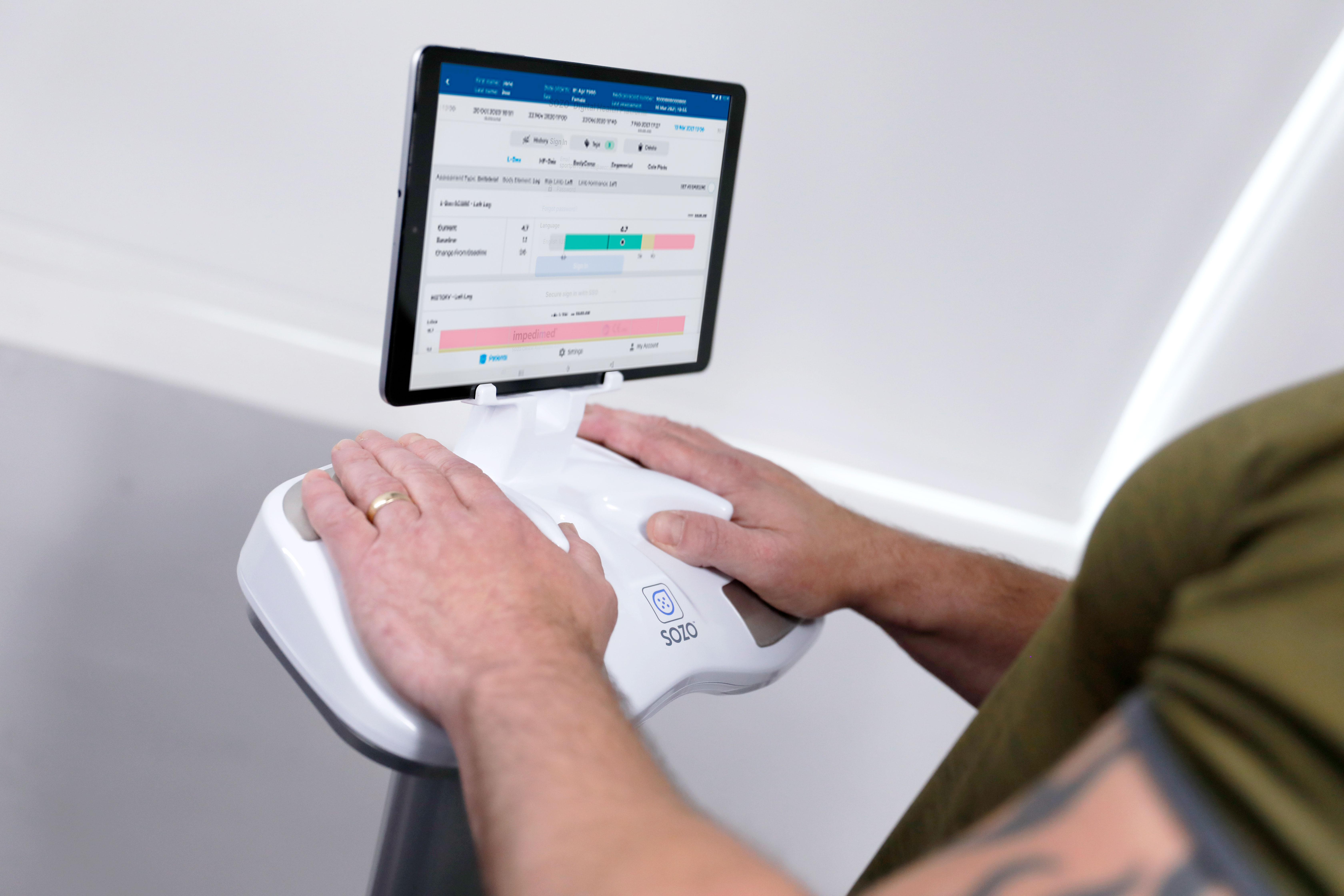Close up photo of the body composition testing equipment with patient placing both hands on the sensors