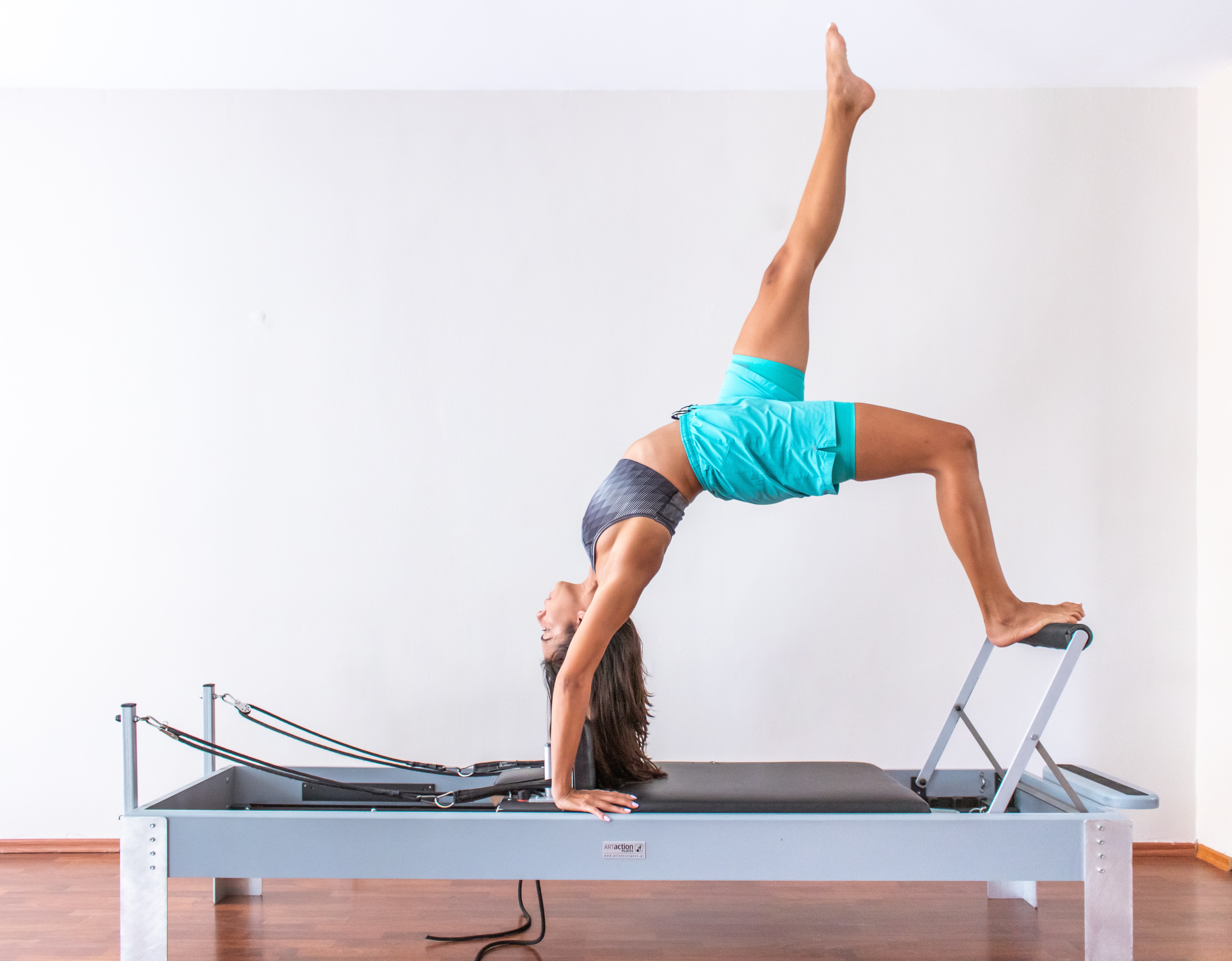 young woman performing stretches on an elevated exercise frame